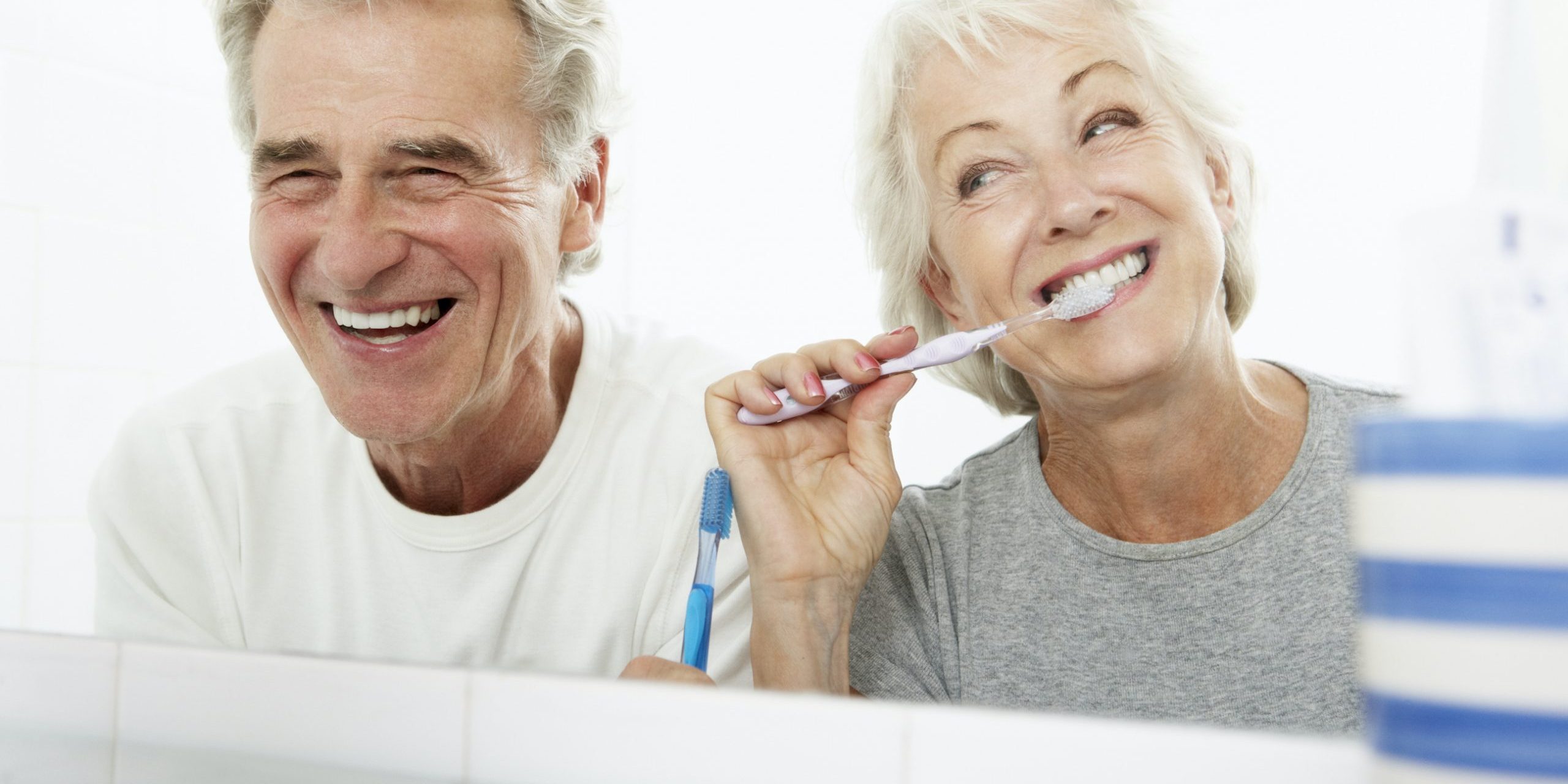 Senior Couple In Bathroom Brushing Teeth