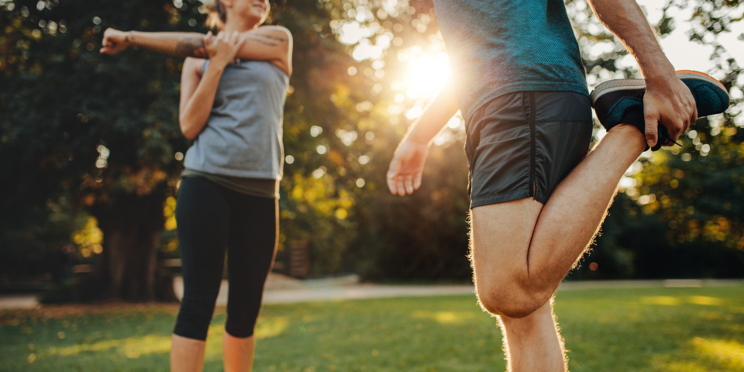 Young man and woman stretching in the park